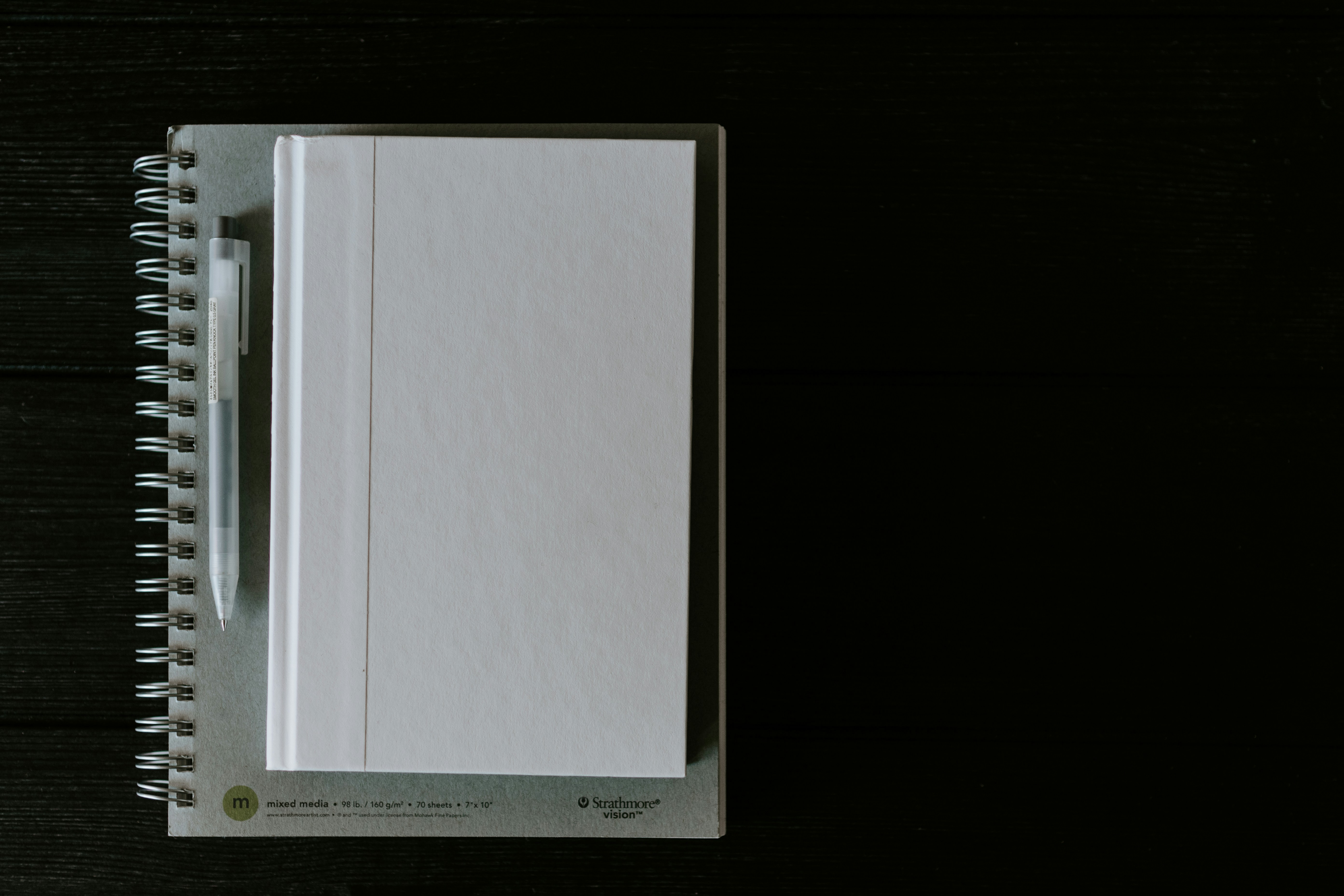 White blank book on a gray spiral notebook